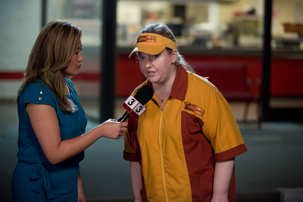 A reporter interviews Becky (Sarah Baker) following the robbery