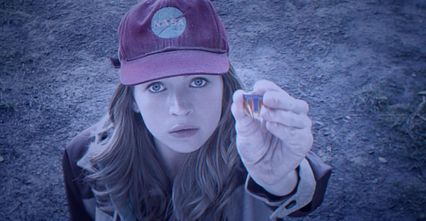 Casey (Britt Robertson) holds up the magical pin in TOMORROWLAND