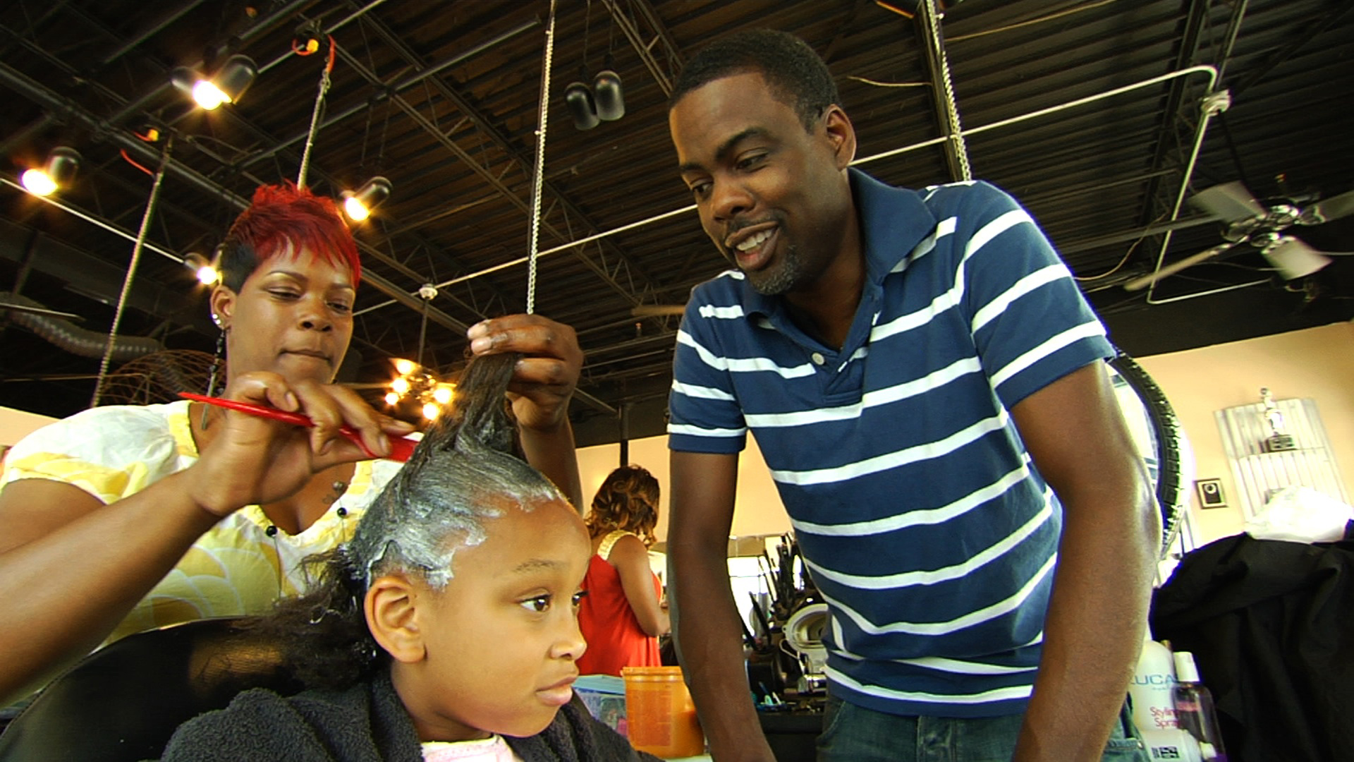 Chris watching stylist use sodium hydroxide straightener in child's hair