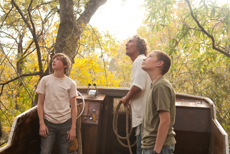Matthew McConaughey, Tye Sheridan, Jacob Lofland in a boat up a tree in MUD