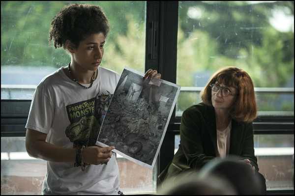 A student shows teacher Anne Gueguen (Ariane Ascaride) a drawing from the Holocaust in ONCE IN A LIFETIME 