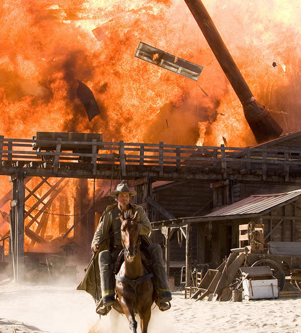 Jonah Hex (Brolin) rides away from exploding town